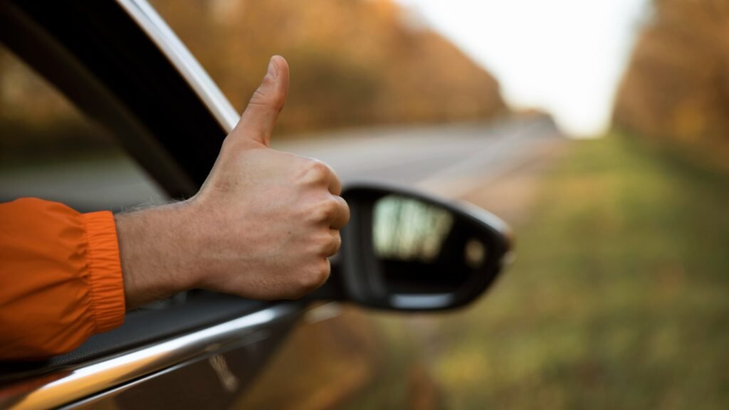 giving-thumbs-up-out-his-car-while-